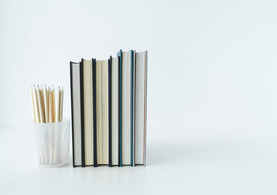 Cup of pencils with 6 books stacked next to it